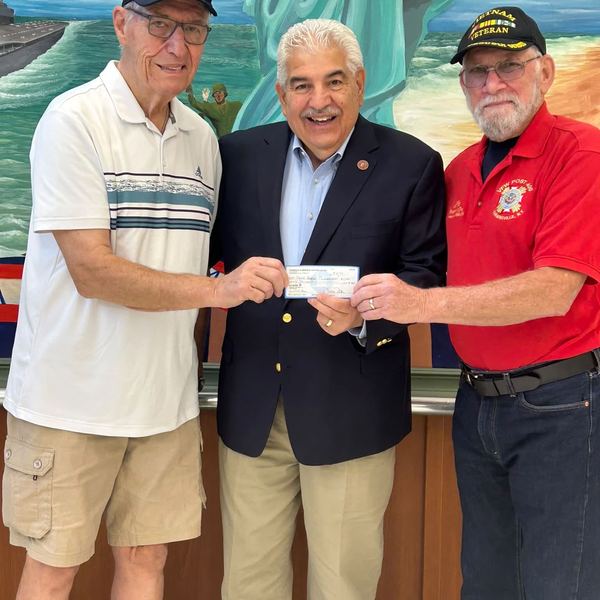 Three men holding a donation check